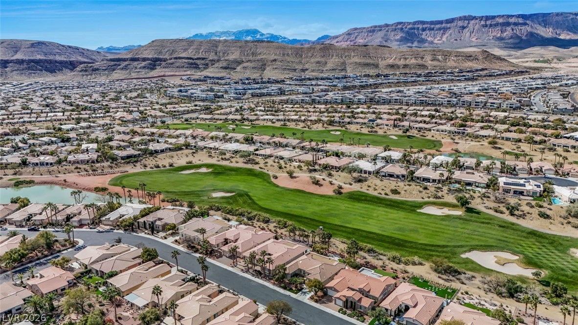 5015 Rivedro Street Las Vegas, NV 89135 - Photo 10 of 91 An aerial perspective reveals a vibrant golf course community nestled against a backdrop of distant mountains.