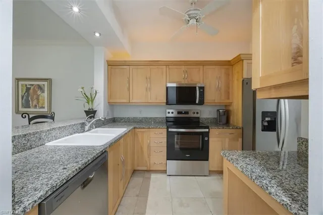 a kitchen with granite countertop a sink stove and refrigerator