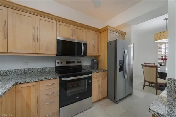 a kitchen with stainless steel appliances granite countertop a refrigerator stove and sink