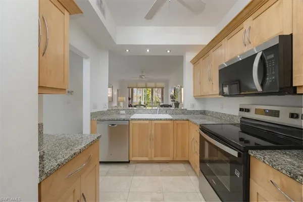 a kitchen with stainless steel appliances granite countertop a sink stove and microwave