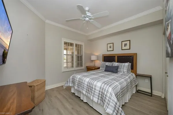 a bedroom with a large bed and a ceiling fan