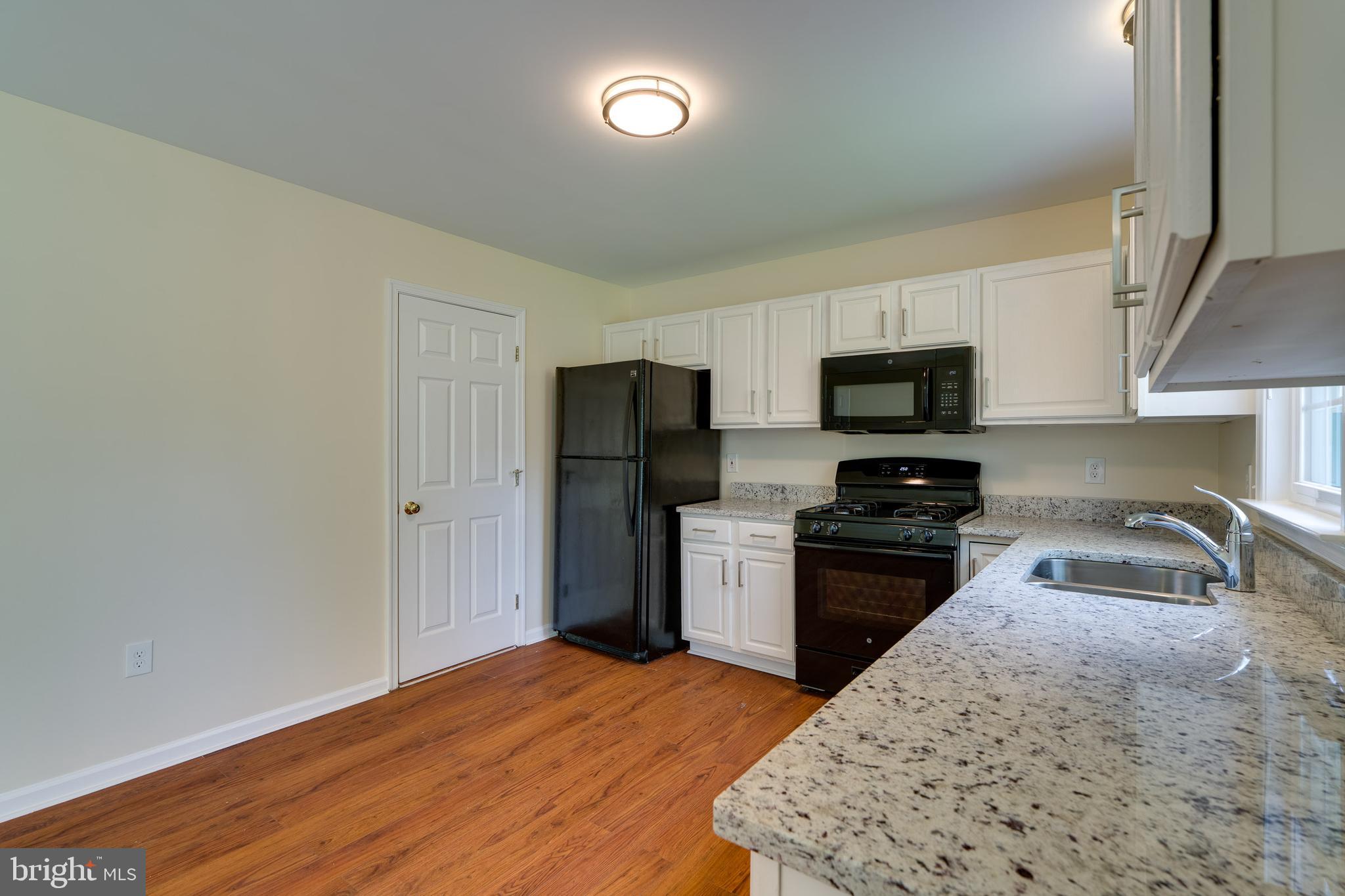 25 Tupelo Street Lititz, PA 17543 - Photo 7 of 20 a kitchen with granite countertop a refrigerator stove top oven a sink and dishwasher