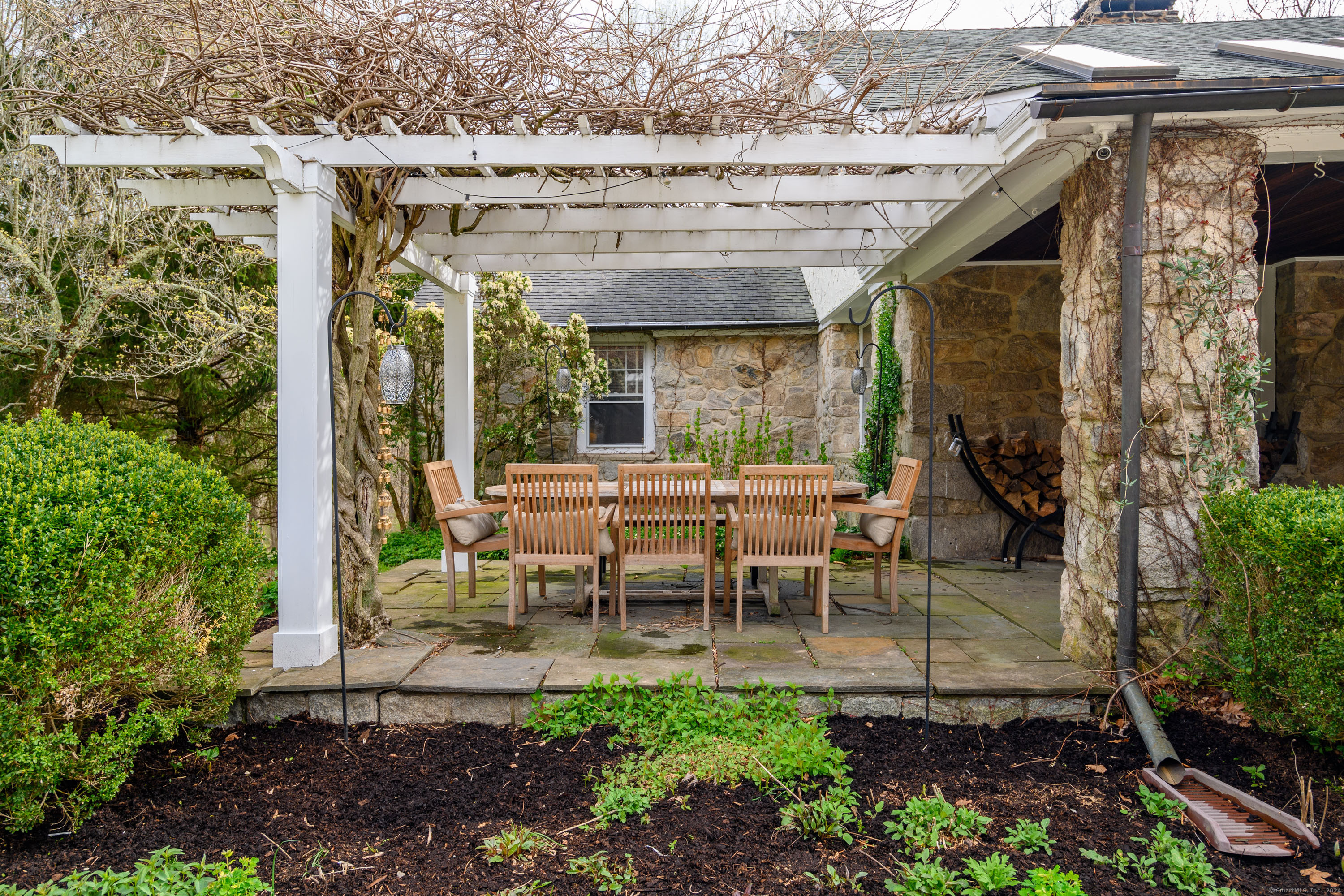58 Woodchuck Lane Ridgefield, CT 06877 - Photo 5 of 38 a view of a patio with table and chairs potted plants and large tree