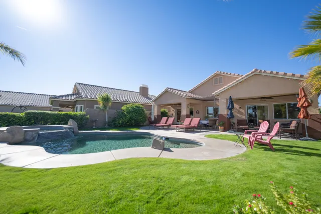 a view of a house with swimming pool and a yard