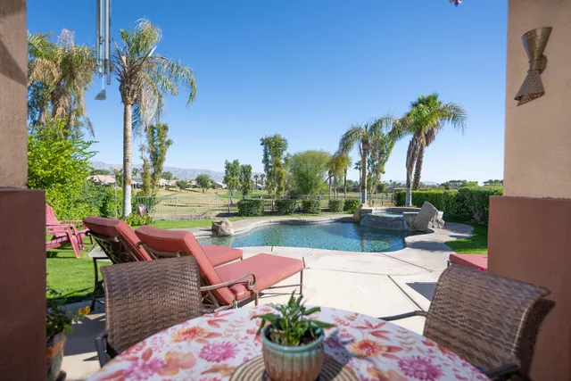 a view of a patio with couches table and chairs potted plants and palm tree
