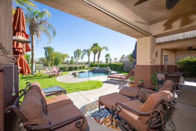 a view of a patio with couches table and chairs potted plants