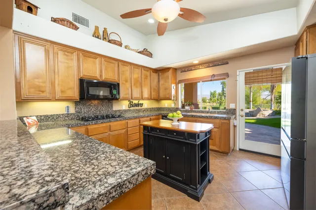 a kitchen with stainless steel appliances granite countertop sink stove and refrigerator