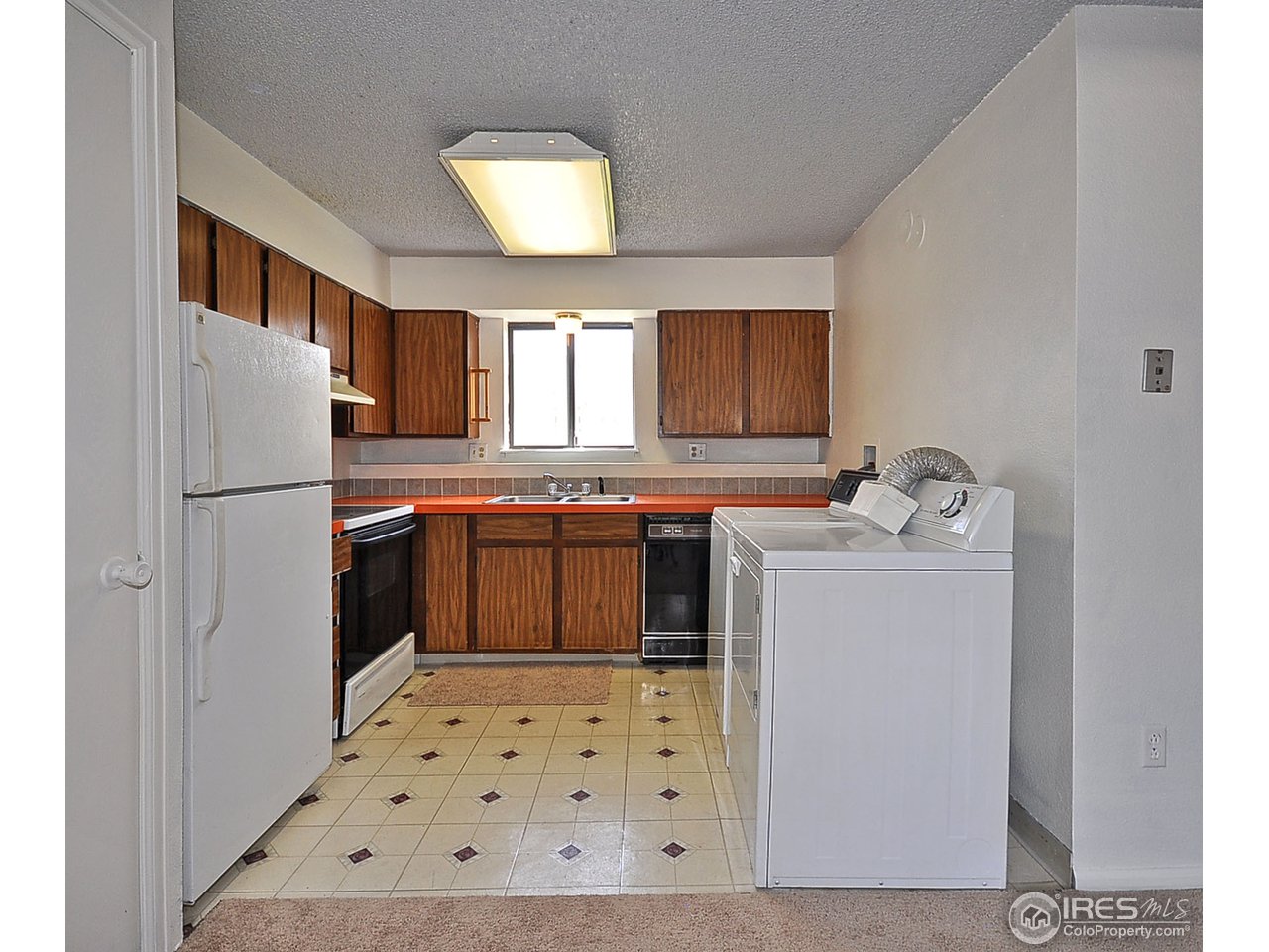 2628 Redwing Road, Unit 2A Fort Collins, CO 80526 - Photo 3 of 16 a kitchen with a sink a refrigerator a window and cabinets