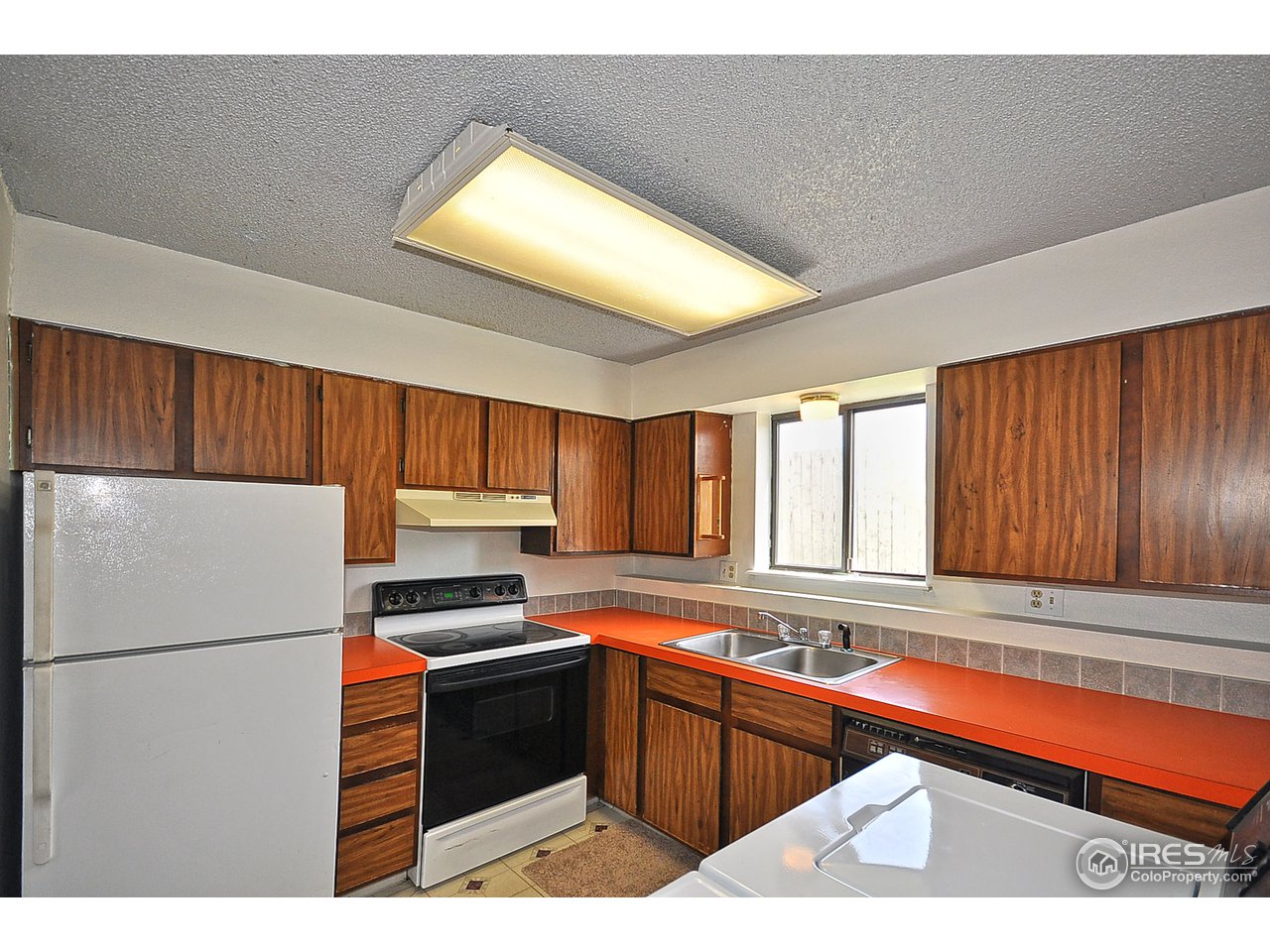 2628 Redwing Road, Unit 2A Fort Collins, CO 80526 - Photo 4 of 16 a kitchen with granite countertop a refrigerator a sink dishwasher a stove and white countertops with cabinets