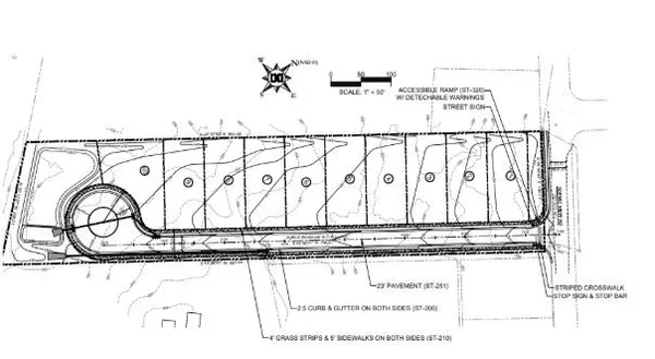 an aerial view of a residential houses with outdoor space and trees all around