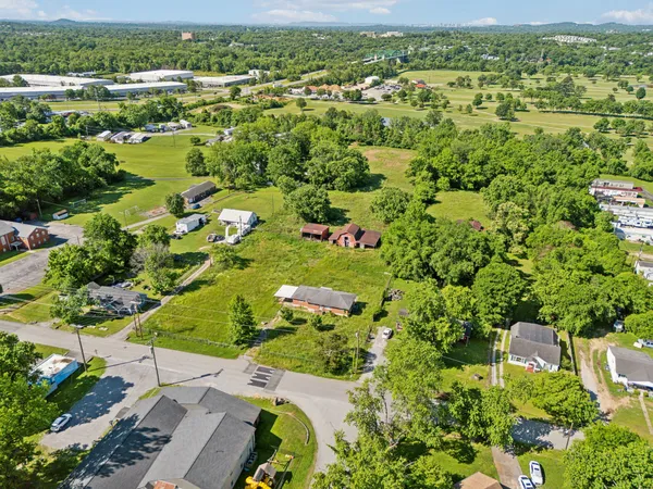 an aerial view of residential houses with outdoor space and trees