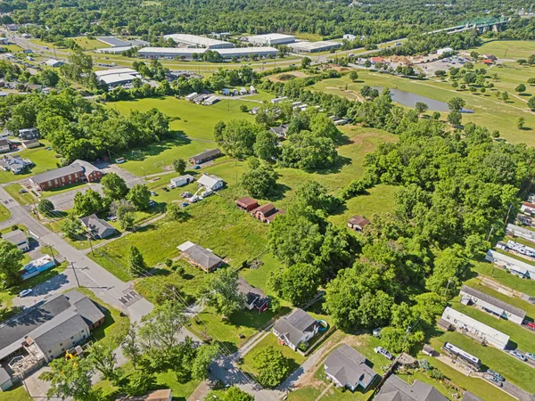 an aerial view of residential houses with outdoor space and trees