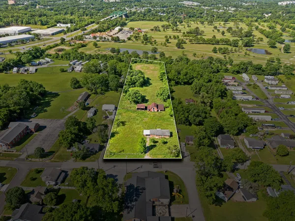 an aerial view of residential houses with outdoor space and trees