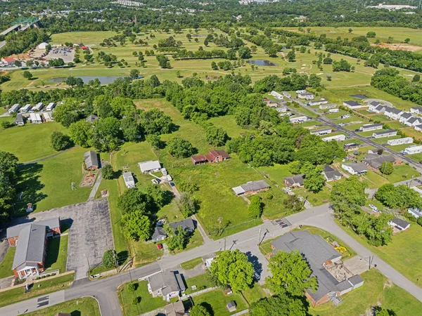 an aerial view of ocean with residential houses with outdoor space and trees