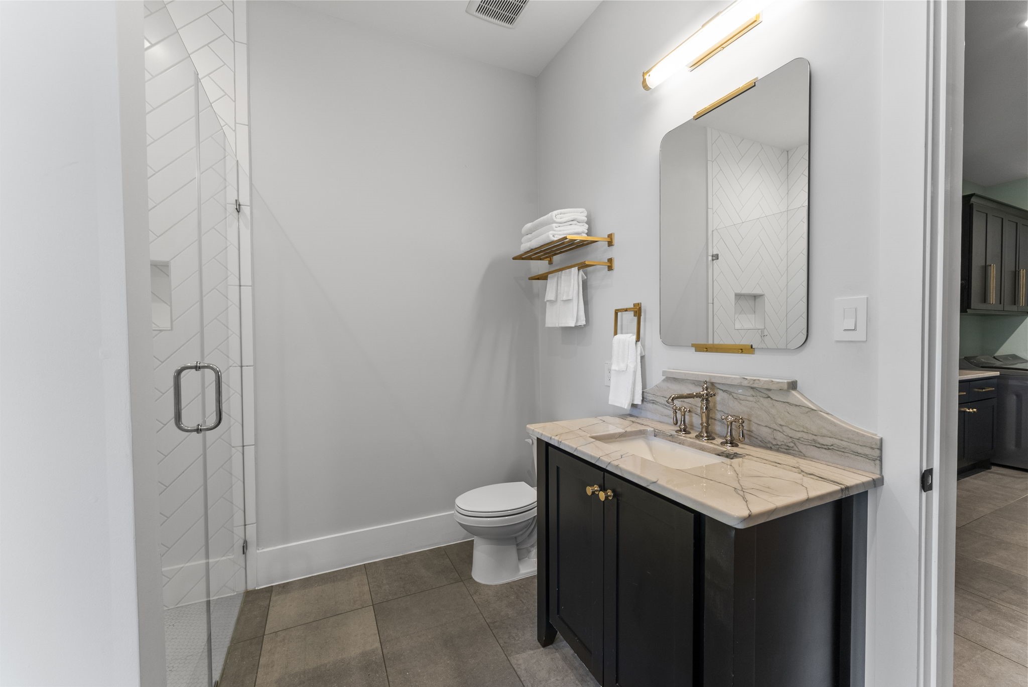 14019 Beartooth Bend Trail Conroe, TX 77384 - Photo 21 of 28 Contemporary secondary bathroom with modern finishes, walk-in glass shower, and door leading to the outdoor patio.