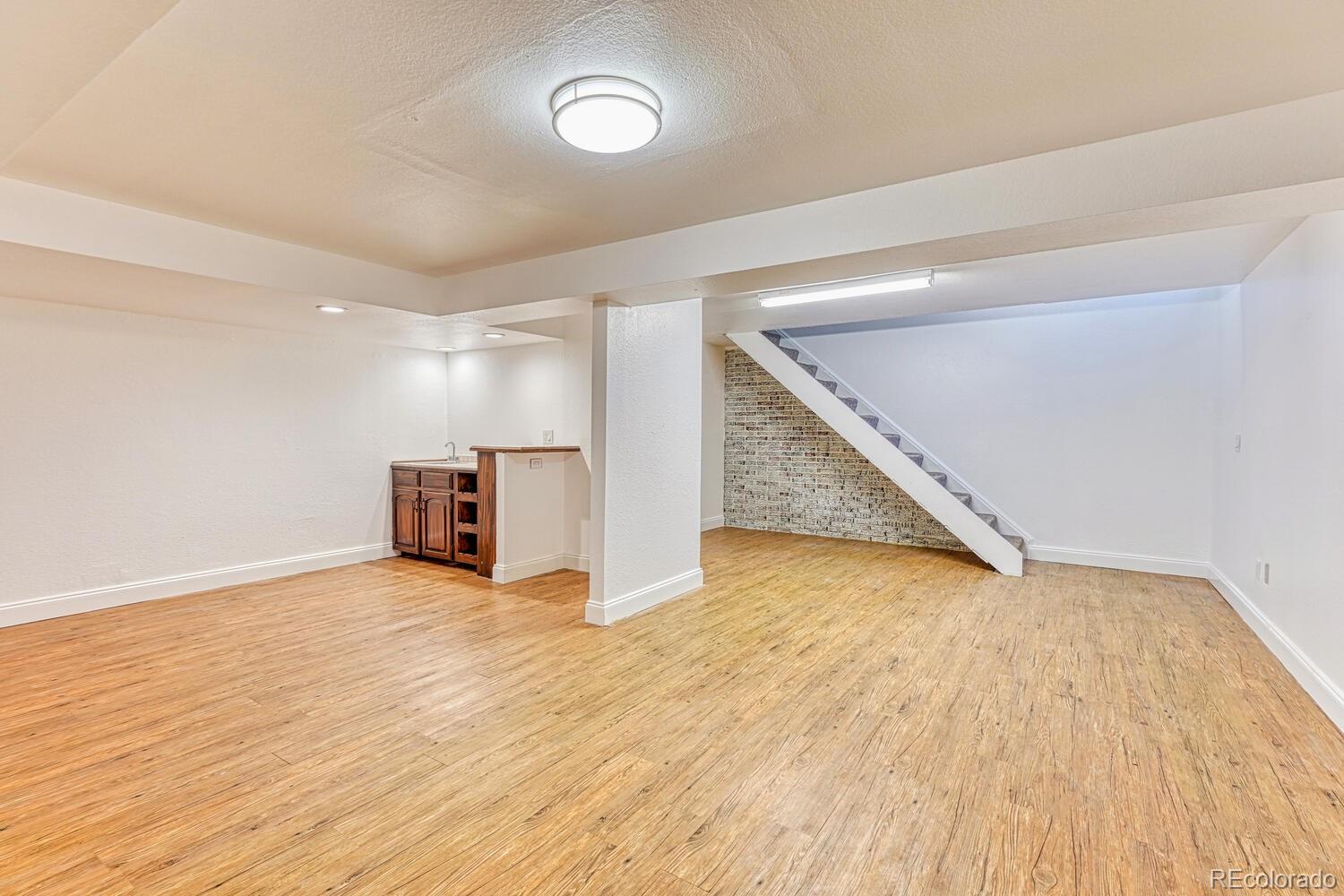 8224 Sweet Water Road Lone Tree, CO 80124 - Photo 25 of 38 a view of an empty room with wooden floor and stairs