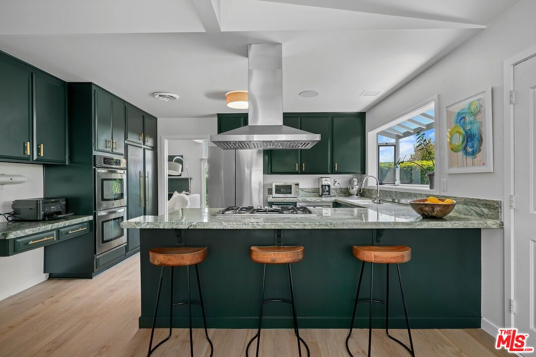 3516 Shoreheights Drive Malibu, CA 90265 - Photo 13 of 29 a kitchen with stainless steel appliances a dining table and chairs