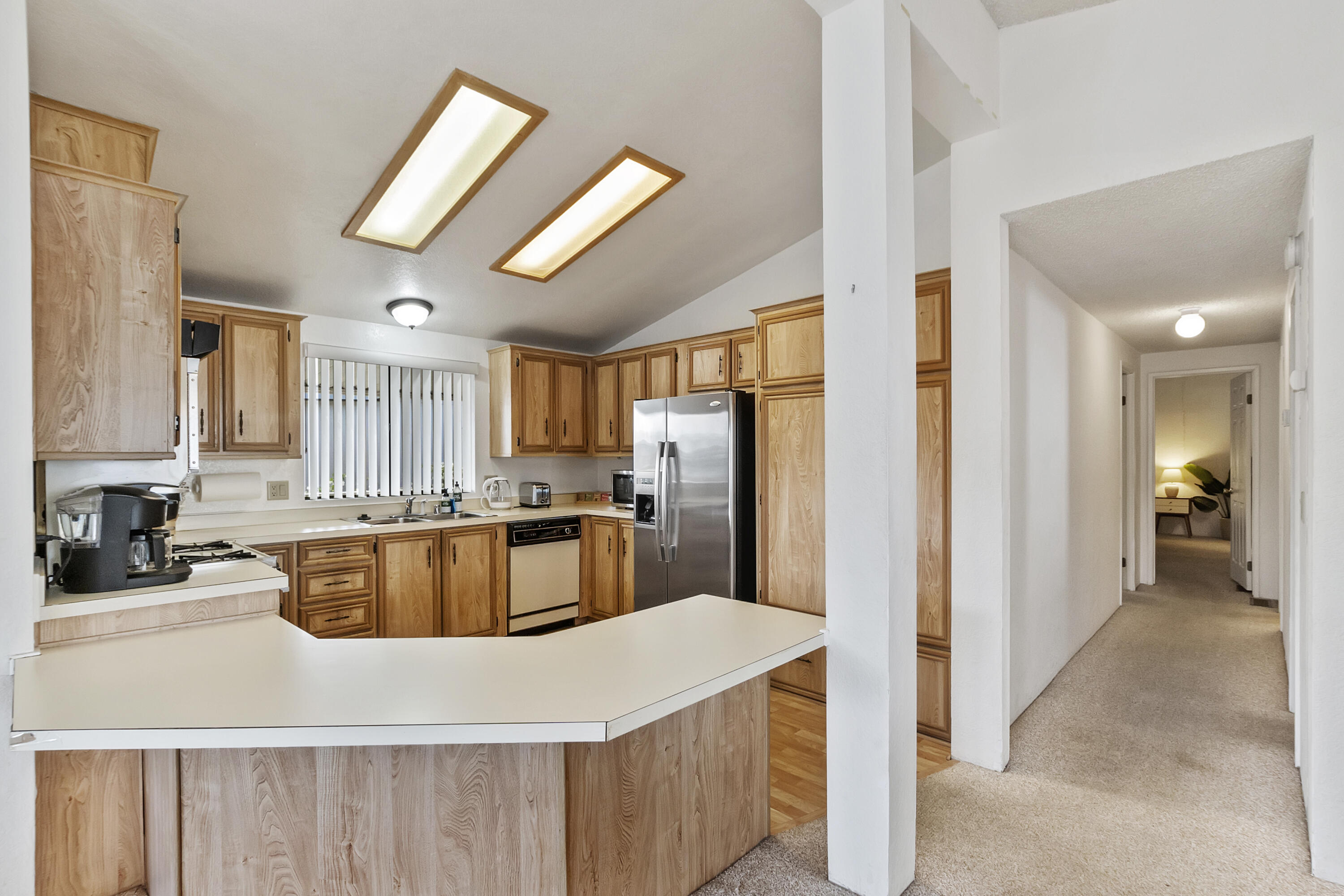 74711 Dillon Road, Unit 545 Desert Hot Springs, CA 92241 - Photo 13 of 42 a kitchen with stainless steel appliances granite countertop a refrigerator a sink dishwasher a stove with white cabinets and wooden floor
