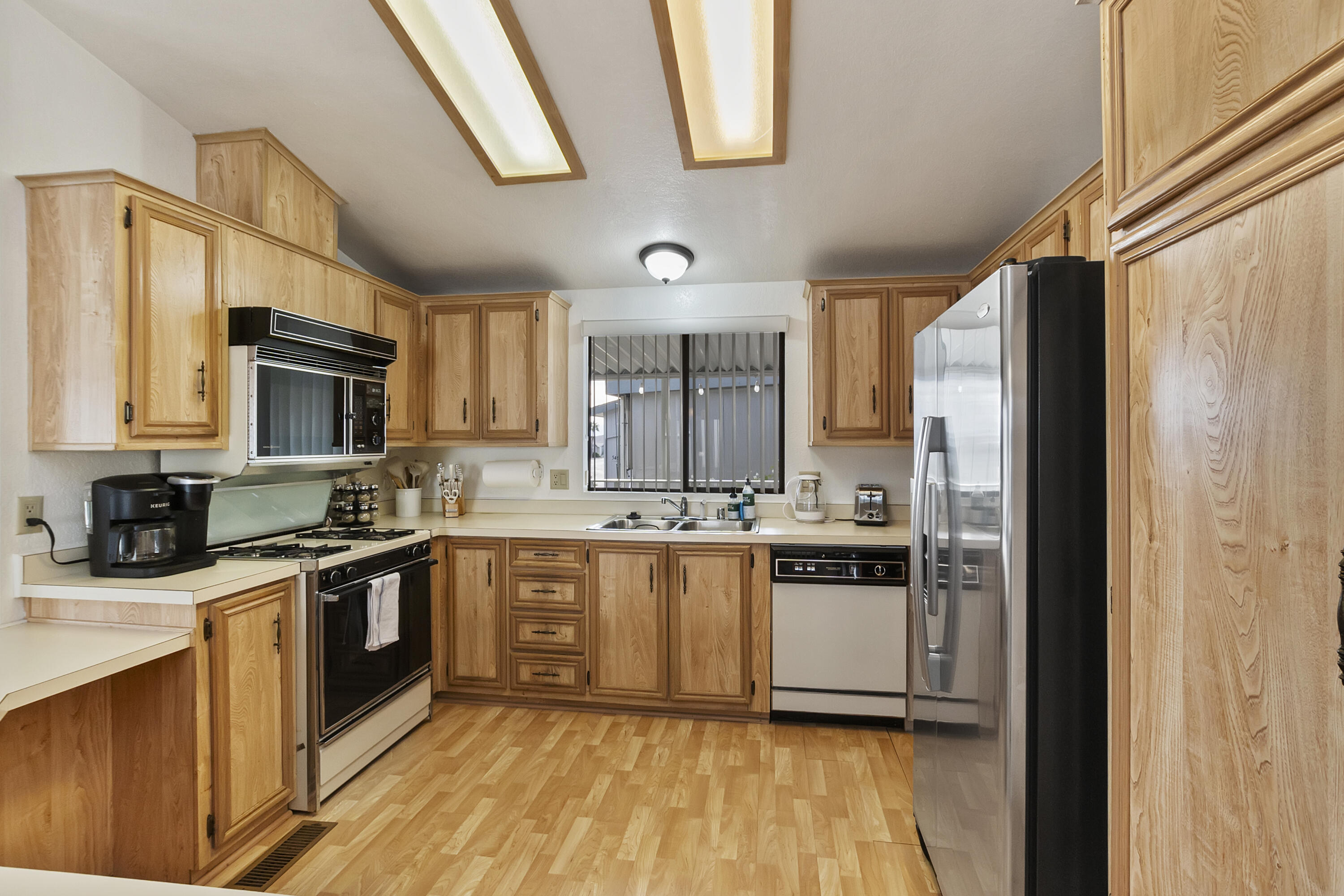 74711 Dillon Road, Unit 545 Desert Hot Springs, CA 92241 - Photo 14 of 42 a kitchen with stainless steel appliances granite countertop a stove a sink and a refrigerator
