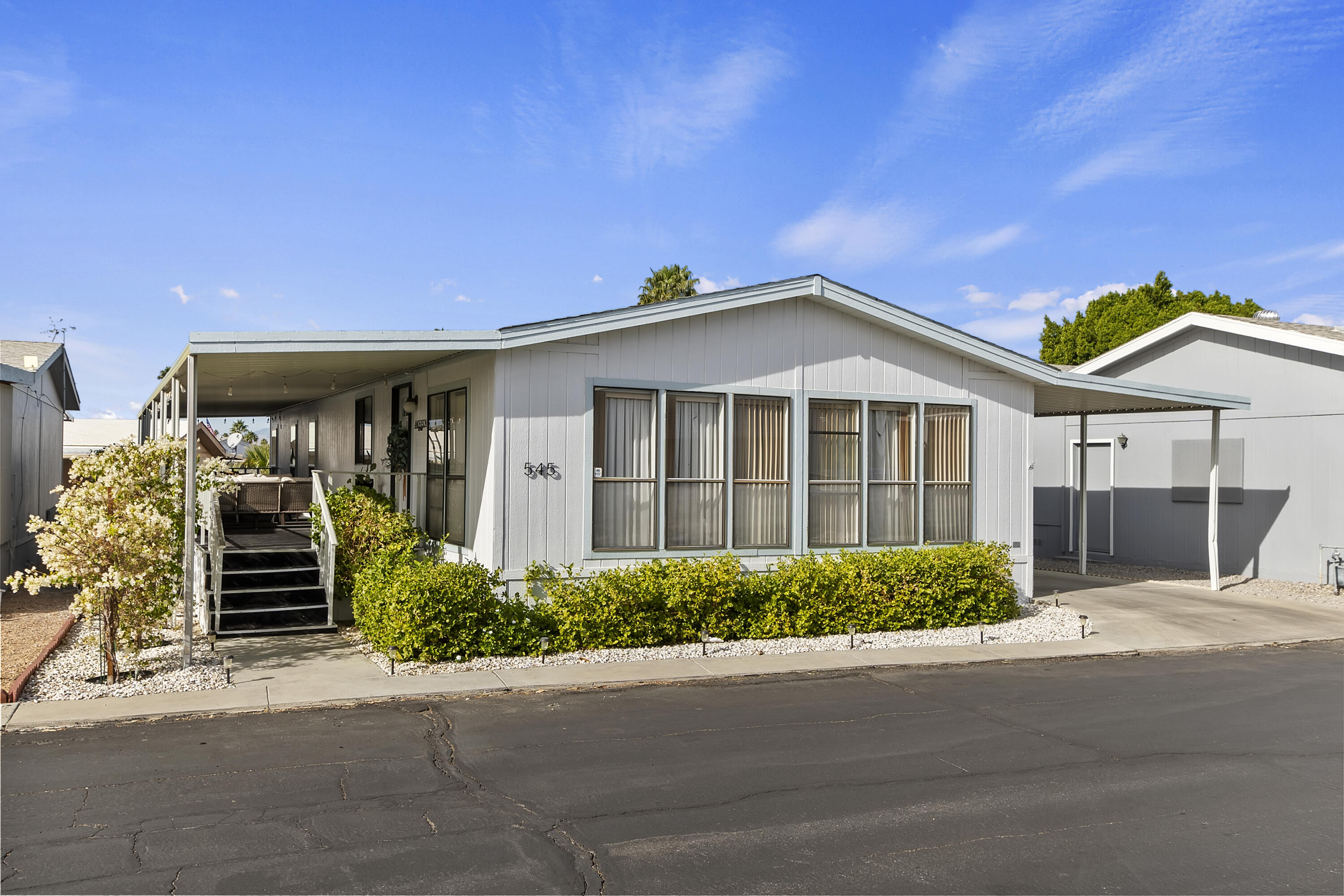 74711 Dillon Road, Unit 545 Desert Hot Springs, CA 92241 - Photo 2 of 42 a front view of a house with a garden