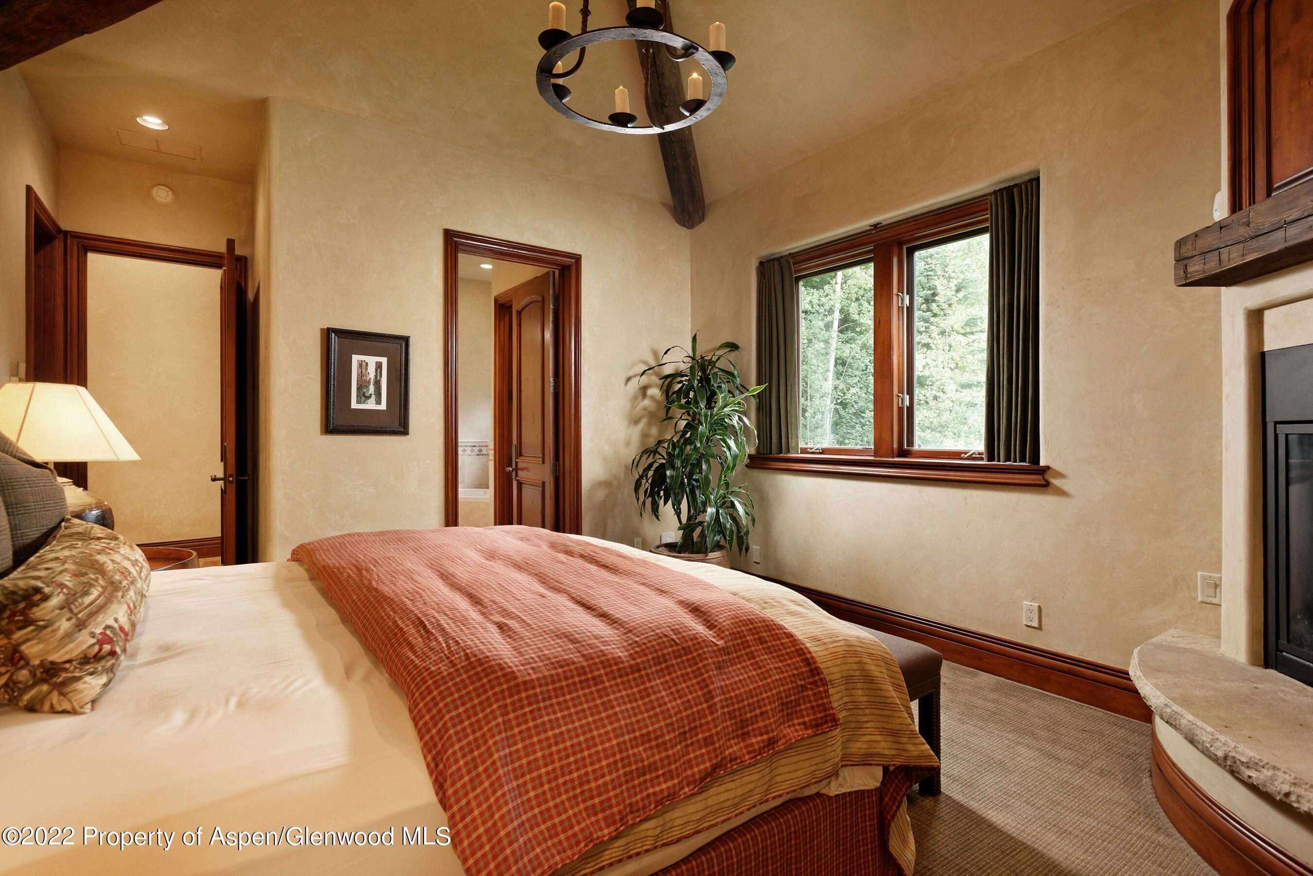 1225 Riverside Drive Aspen, CO 81611 - Photo 18 of 21 a bedroom with a bed and a chandelier