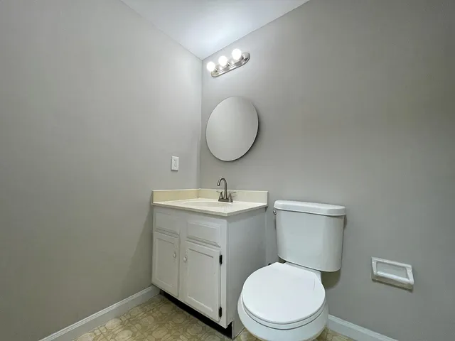 a bathroom with a toilet a sink and mirror