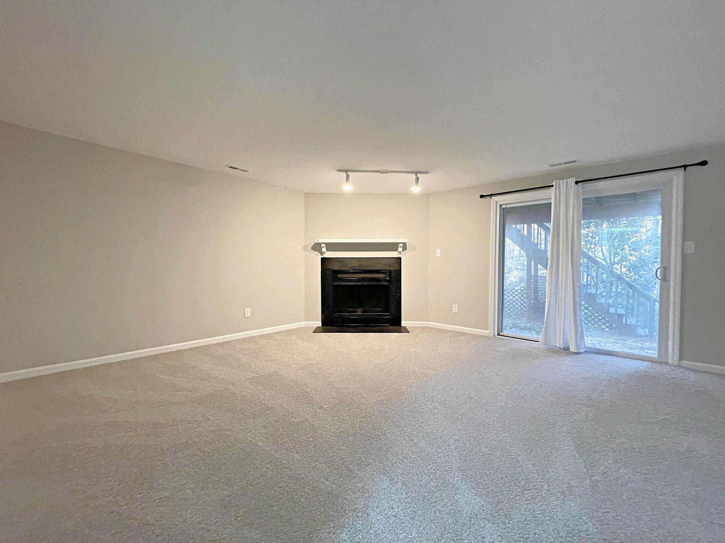 7328 Summerland Drive Raleigh, NC 27612 - Photo 17 of 27 a view of an empty room with a fireplace and a window
