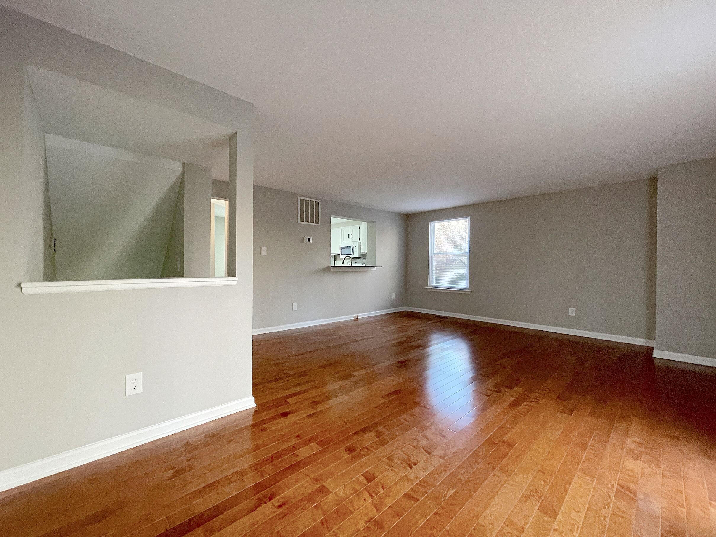 7328 Summerland Drive Raleigh, NC 27612 - Photo 6 of 27 an empty room with wooden floor and windows
