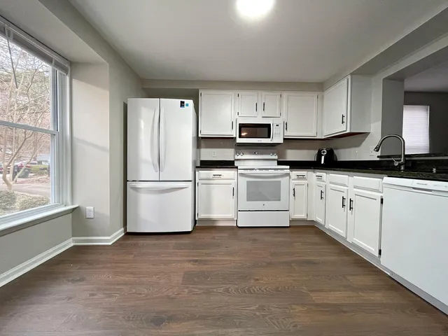 a kitchen with white cabinets and white appliances