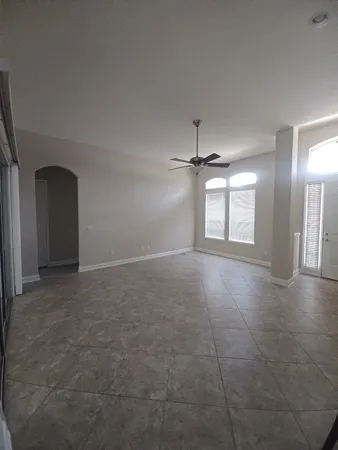an empty room with windows and fireplace
