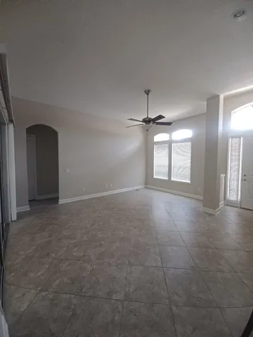 an empty room with windows and fireplace