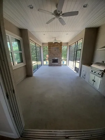 a big room with chandelier fan and windows