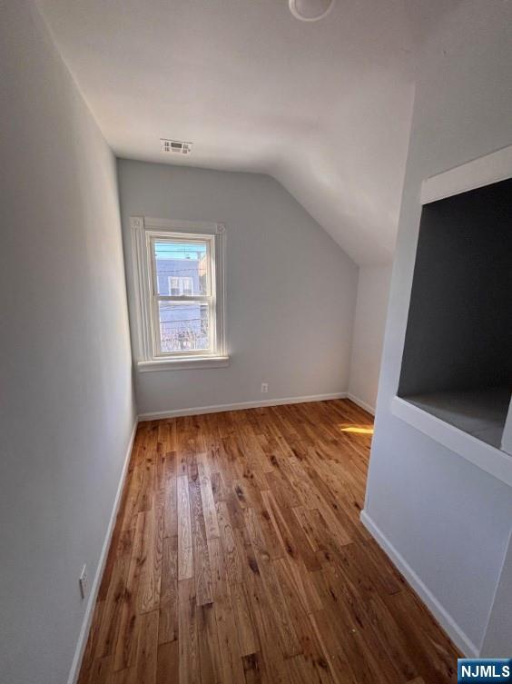 332 70th Street, Unit 2 Guttenberg, NJ 07093 - Photo 4 of 7 an empty room with wooden floor and windows