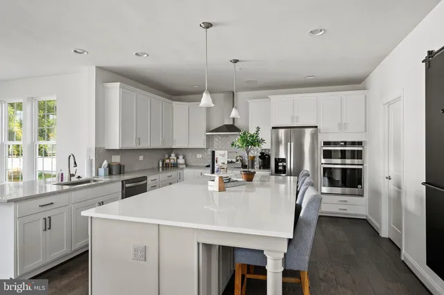 a kitchen with a center island a counter space stainless steel appliances and cabinets