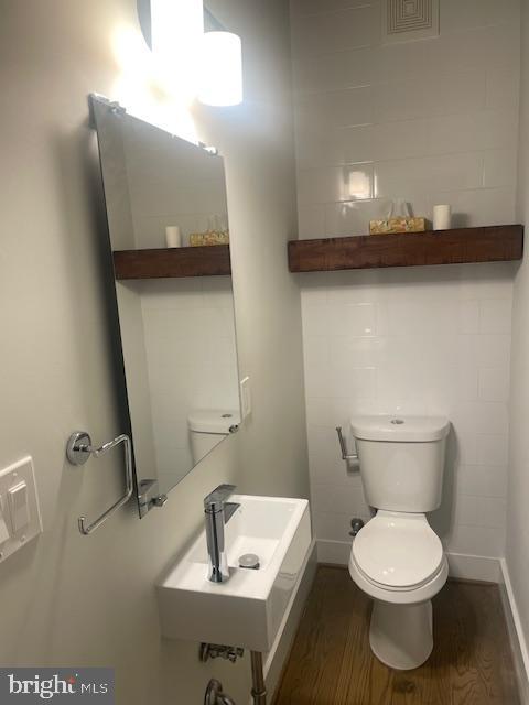 724 Taylor Street Northwest, Unit 1 Washington, DC 20011 - Photo 6 of 36 a bathroom with a toilet a sink and mirror