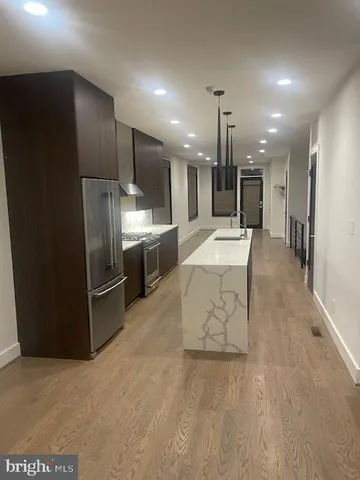 a kitchen with stainless steel appliances kitchen island a sink stove and refrigerator