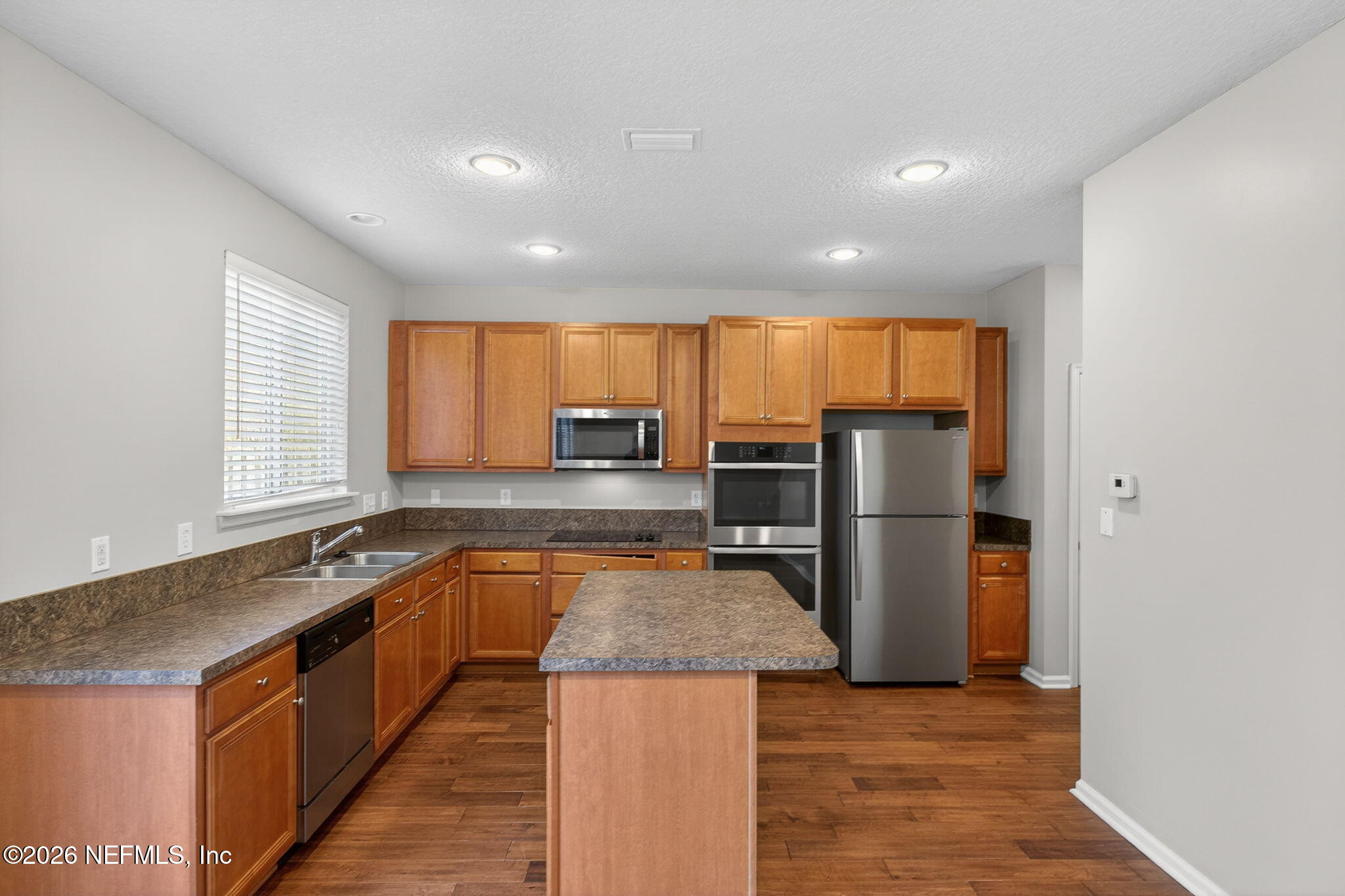 76134 Tideview Lane Yulee, FL 32097 - Photo 25 of 44 a kitchen with stainless steel appliances granite countertop a refrigerator a sink a stove and island