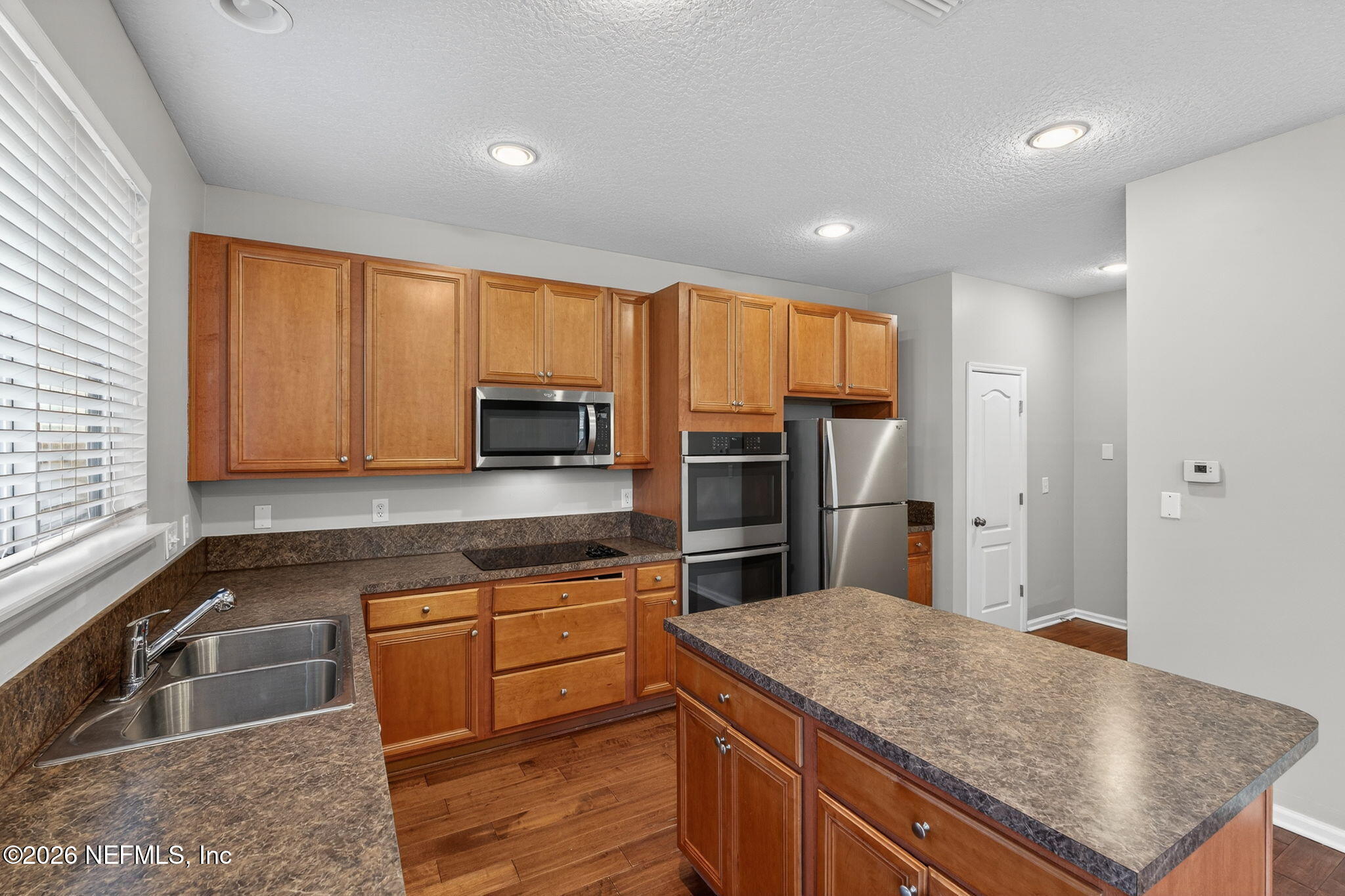 76134 Tideview Lane Yulee, FL 32097 - Photo 26 of 44 a kitchen with stainless steel appliances granite countertop a sink refrigerator and microwave