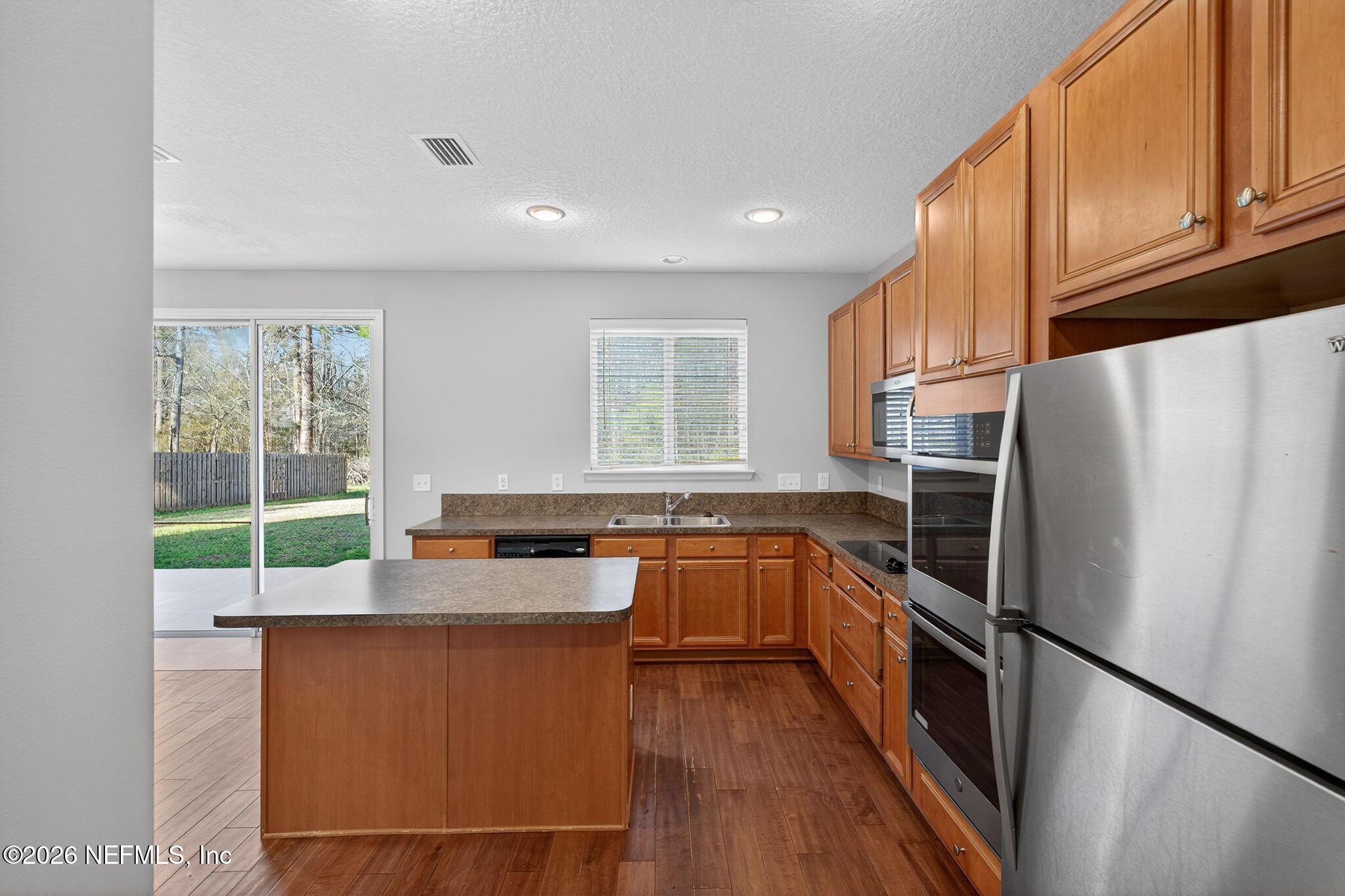 76134 Tideview Lane Yulee, FL 32097 - Photo 27 of 44 a kitchen with granite countertop a refrigerator stove and sink