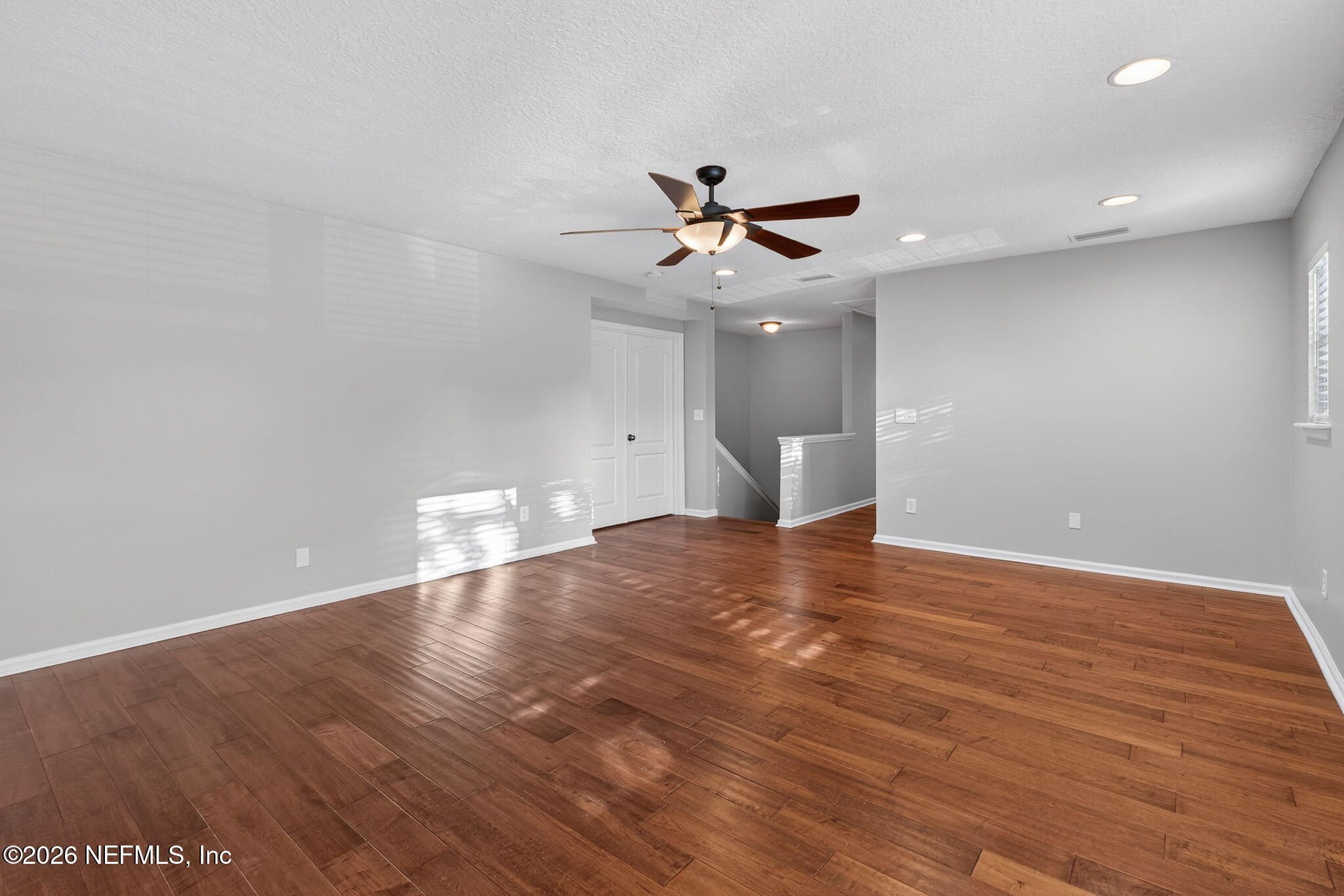 76134 Tideview Lane Yulee, FL 32097 - Photo 30 of 44 a view of a big room with wooden floor and a ceiling fan