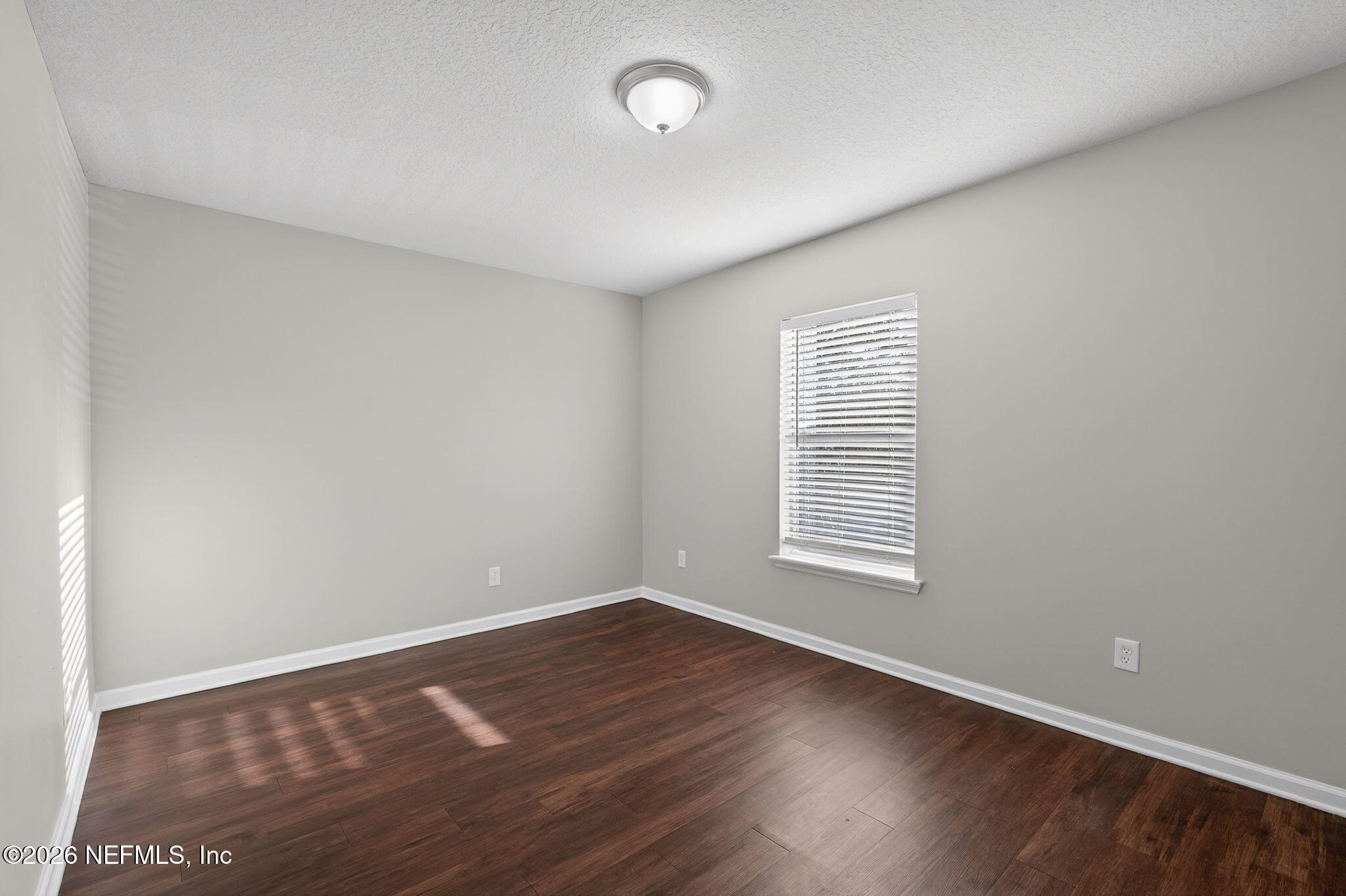 76134 Tideview Lane Yulee, FL 32097 - Photo 31 of 44 an empty room with wooden floor and windows