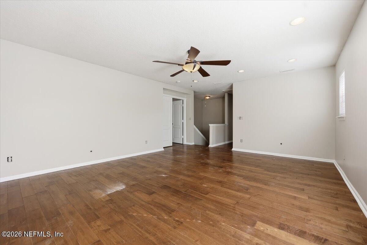 76134 Tideview Lane Yulee, FL 32097 - Photo 8 of 44 a view of an empty room with wooden floor and a ceiling fan