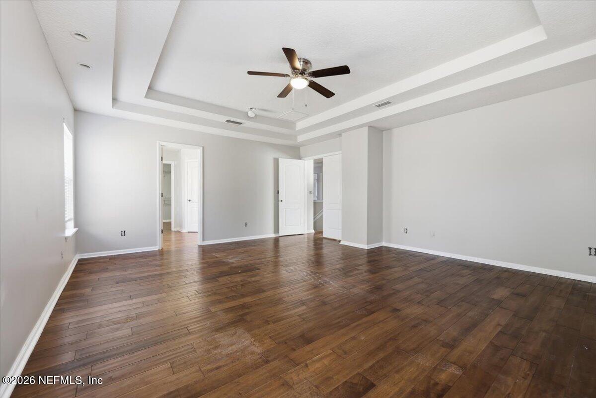 76134 Tideview Lane Yulee, FL 32097 - Photo 9 of 44 a view of an empty room with wooden floor and a ceiling fan