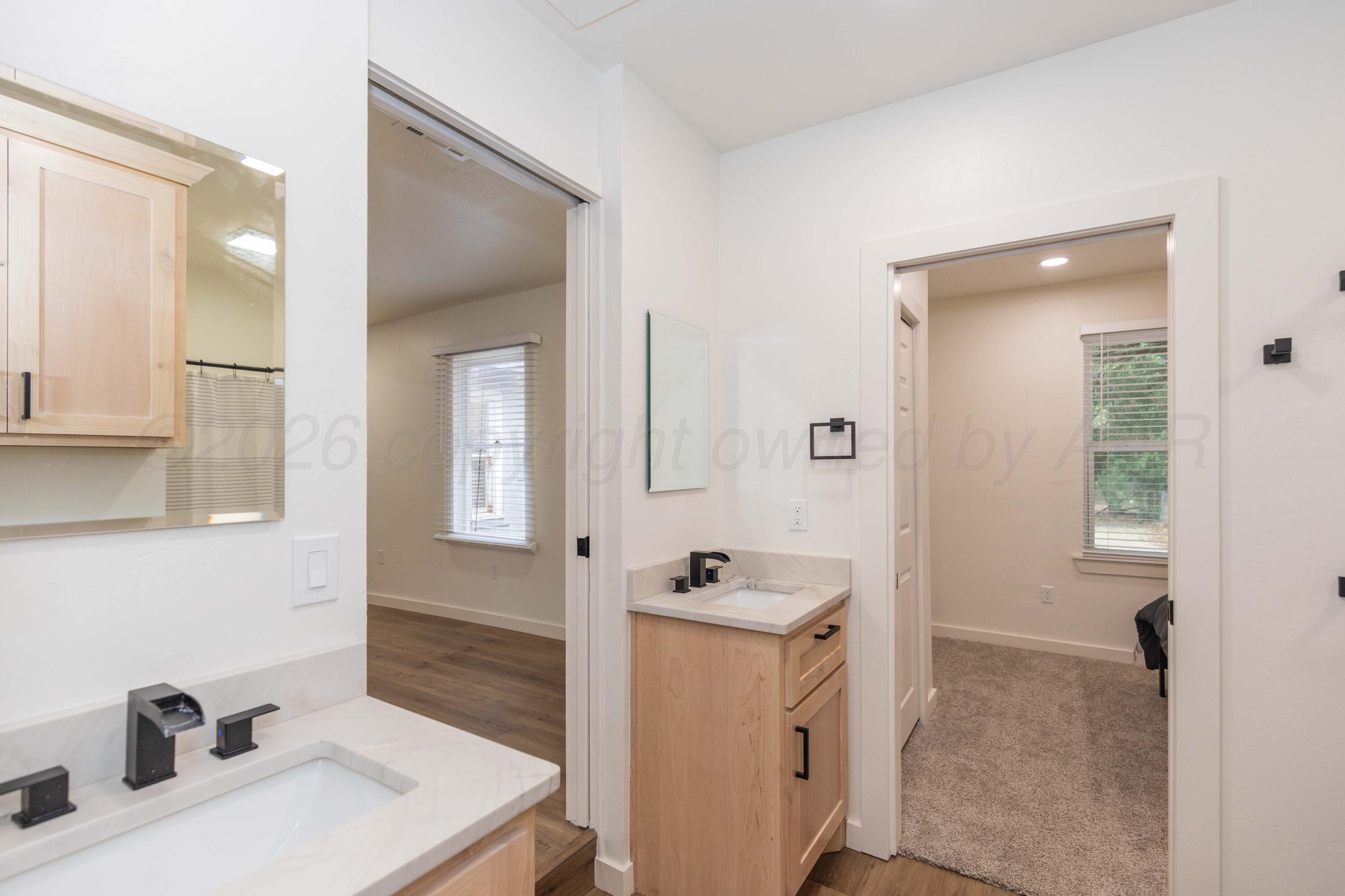504 High Street Claude, TX 79019 - Photo 5 of 39 a bathroom with a sink a toilet and a mirror