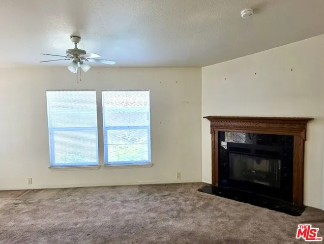 an empty room with windows and fireplace