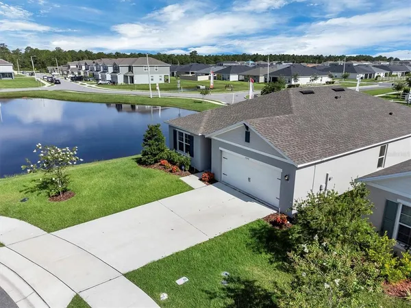 an aerial view of a house with a garden and lake view