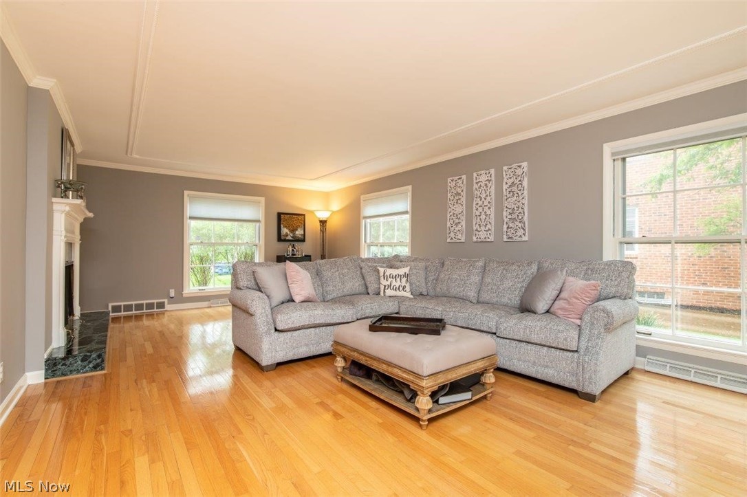 Spacious Living Room with Hardwood Floors, Two Sided Fireplace and Custom Moldings
