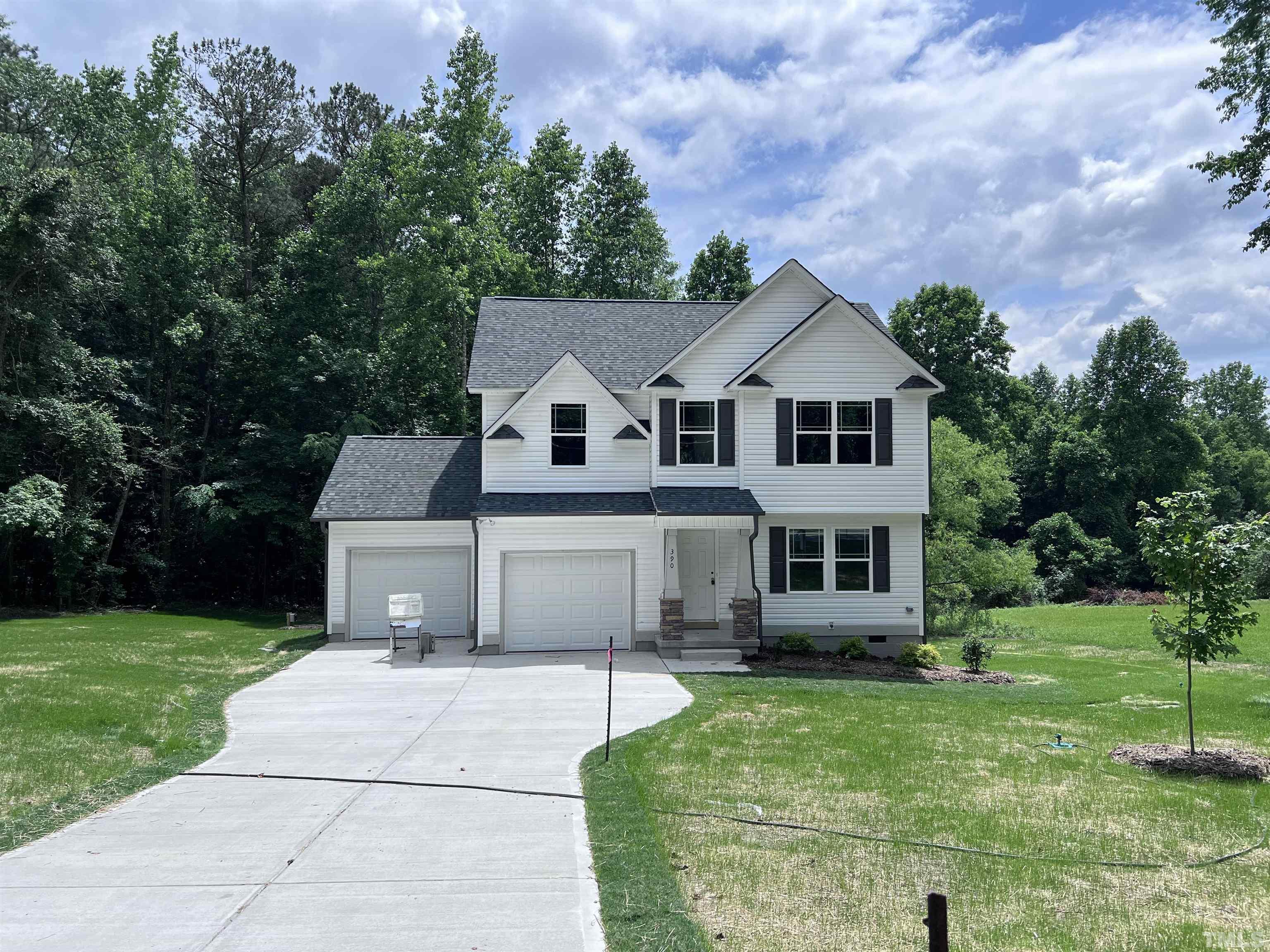 390 Roberts Road Willow Spring, NC 27592 - Photo 1 of 18 a front view of a house with garden