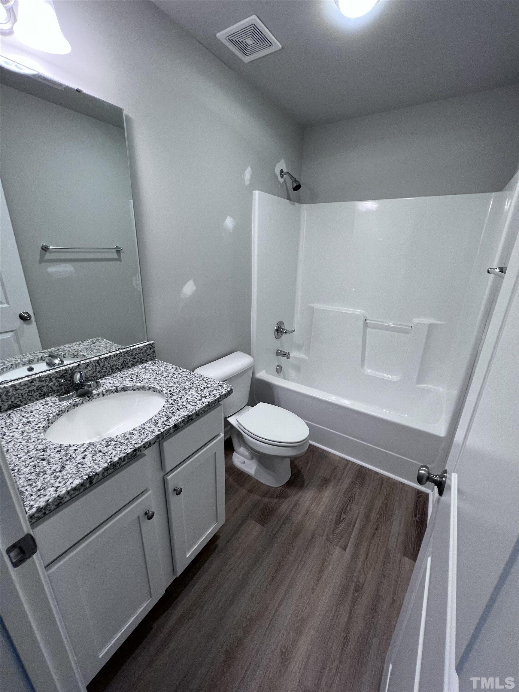 390 Roberts Road Willow Spring, NC 27592 - Photo 17 of 18 a bathroom with a granite countertop sink a toilet and shower