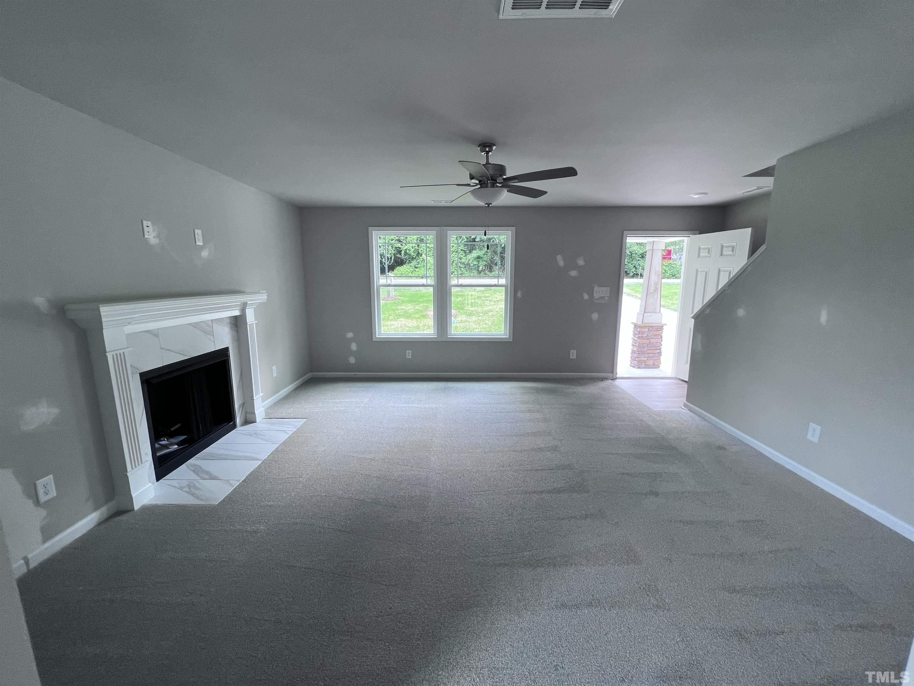 390 Roberts Road Willow Spring, NC 27592 - Photo 3 of 18 a view of empty room with a fireplace and windows
